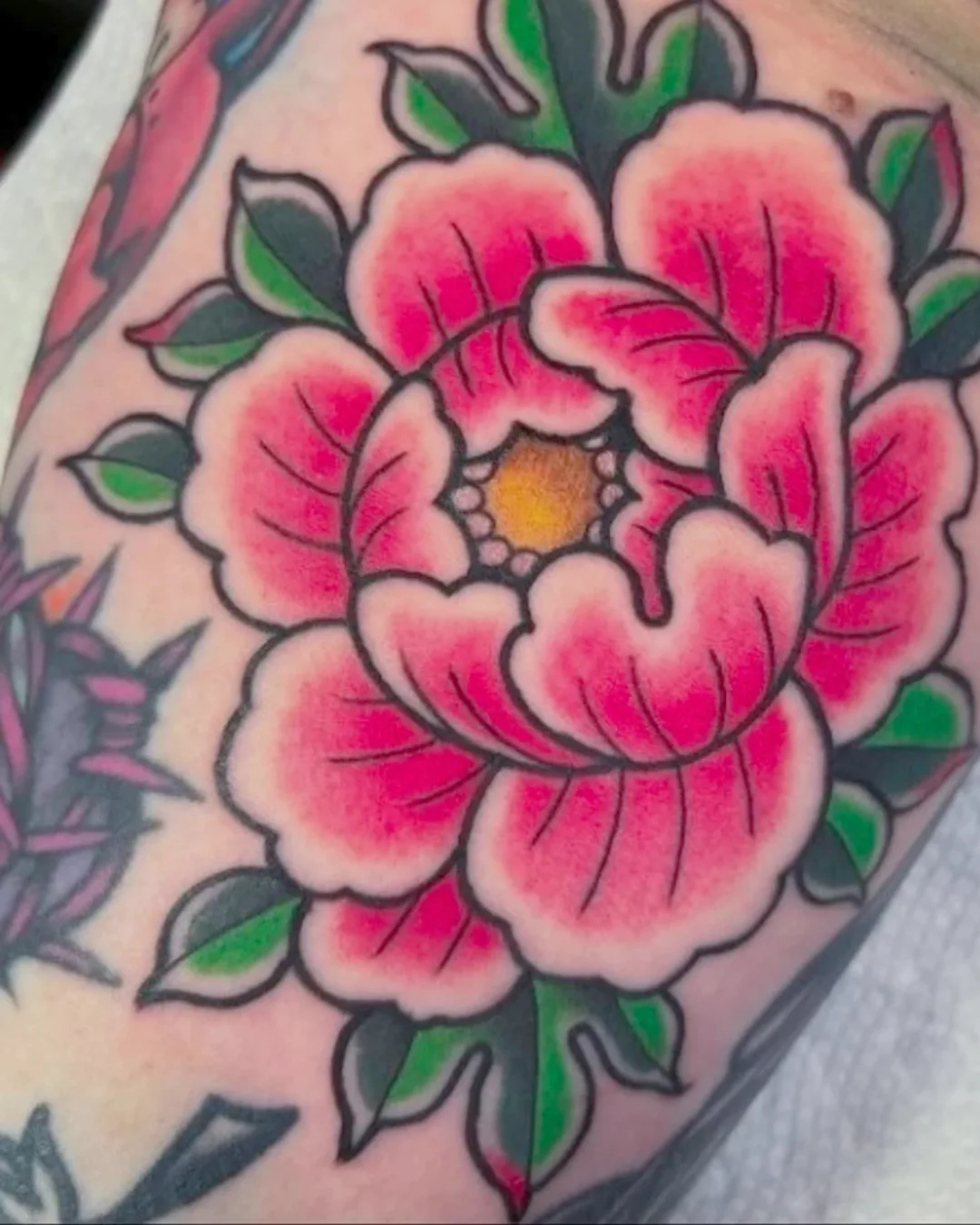 Bold traditional peony on the arm, tattooed by Killian Huckstead